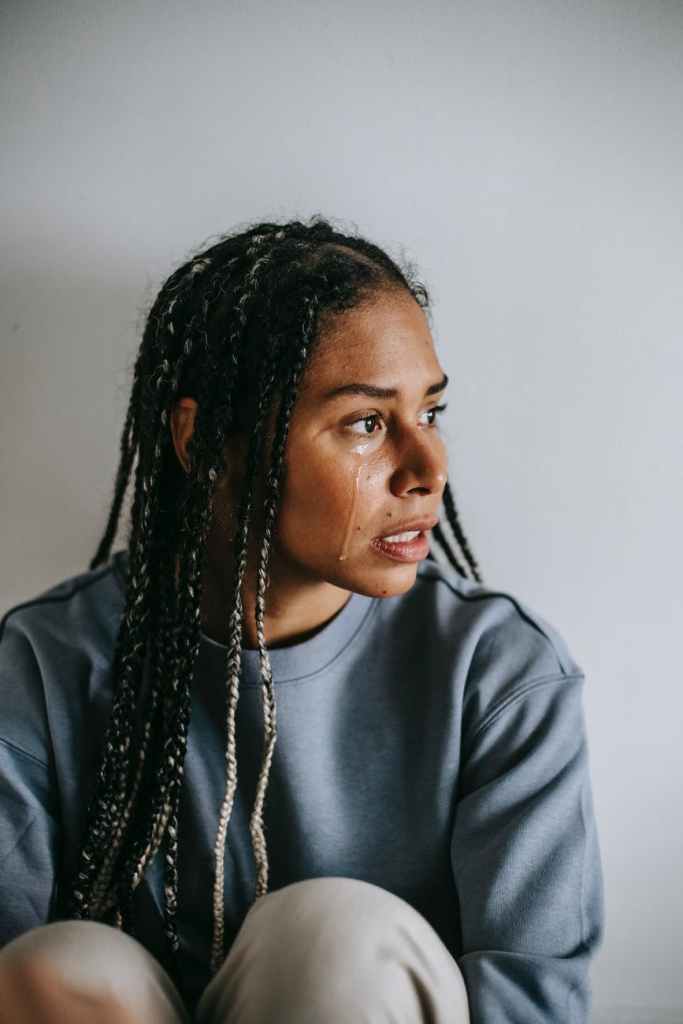 crying black woman resting on light background